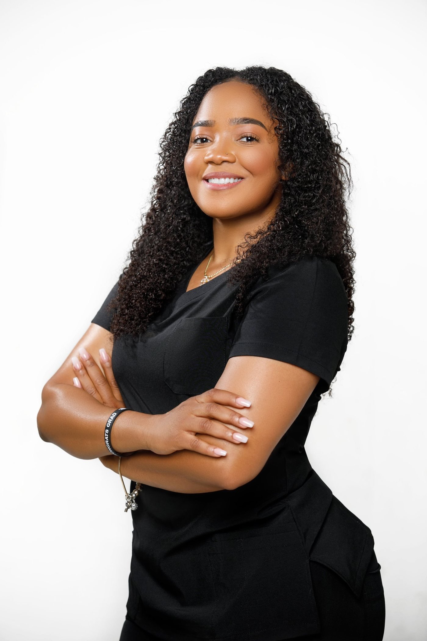 Lou, founder of Shapes by Lou, smiling in black scrubs